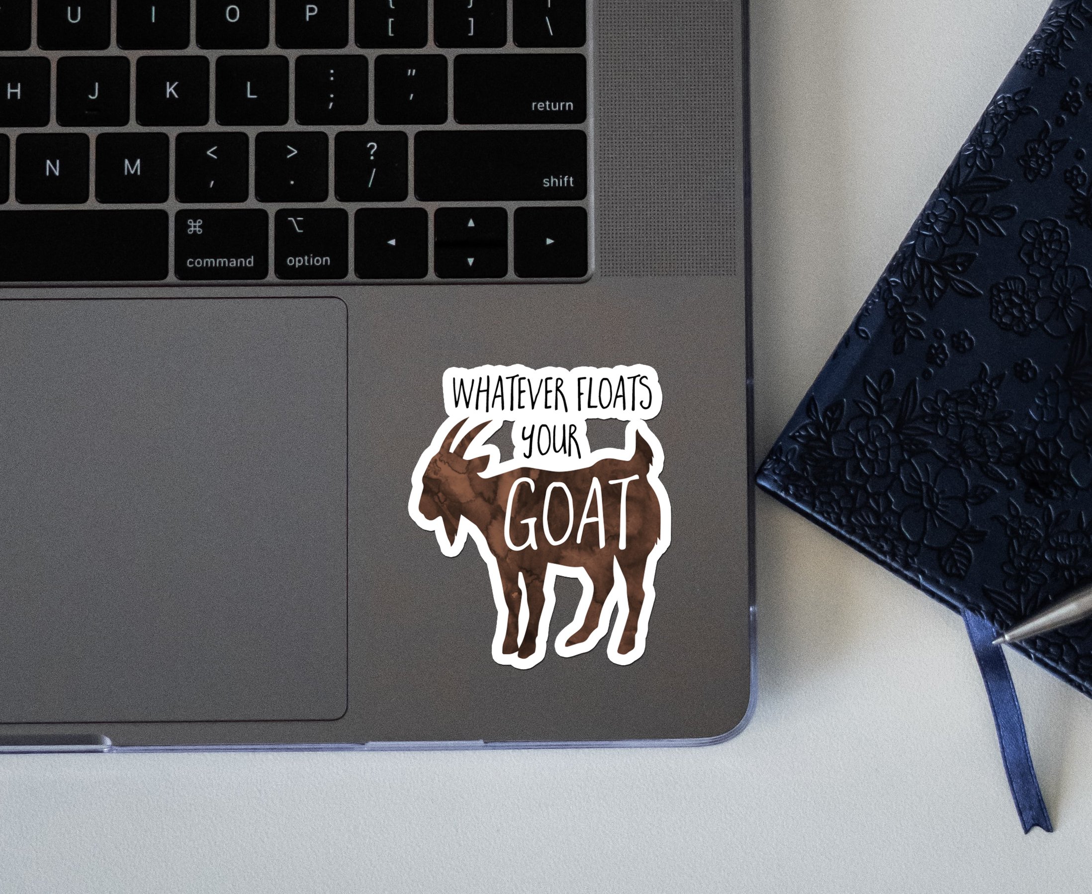 photo of a sticker that says whatever floats your goat on a laptop