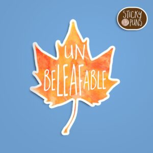 A pun sticker with the word 'UnbeLEAFable' written on an orange fall leaf. Sticker is on a blue background with a sticky puns logo in the top right corner.