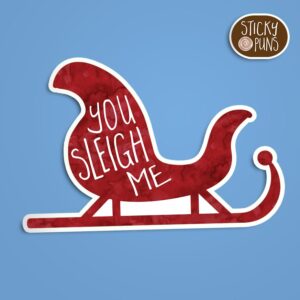 A pun sticker with the phrase 'You SLEIGH Me' written on Santa's sleigh.  Sticker is on a blue background with a sticky puns logo in the top right corner.