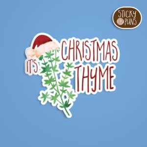 A pun sticker with the phrase 'It's Christmas thyme' written on a sprig of thyme wearing a Santa hat.  Sticker is on a blue background with a sticky puns logo in the top right corner.