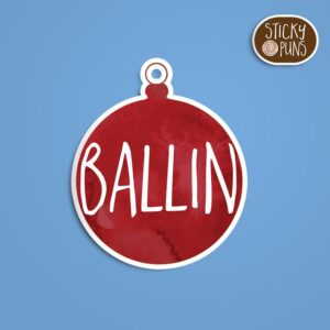 A Christmas pun sticker with the phrase 'Ballin Christmas Pun' written on a round Christmas ornament. Sticker is on a blue background with a sticky puns logo in the top right corner.