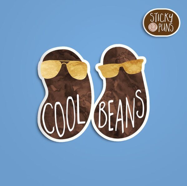 A pun sticker with the phrase 'Cool beans' written on a couple of beans wearing gold sunglasses. Sticker is on a blue background with a sticky puns logo in the top right corner.