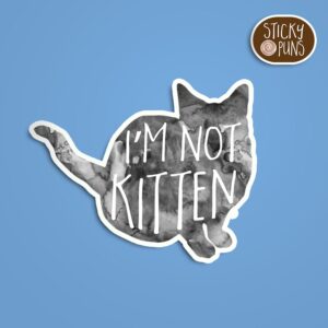 A pun sticker with the phrase 'I'm not KITTEN' featuring an adorable kitten. Sticker is on a blue background with a sticky puns logo in the top right corner.