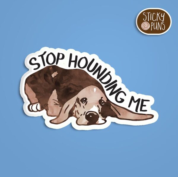 A pun sticker with the phrase 'Stop hounding me' featuring a comical hound dog. Sticker is on a blue background with a sticky puns logo in the top right corner.