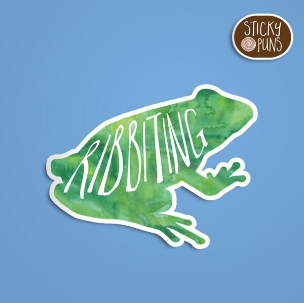 A pun sticker with the word 'ribbiting' and a frog. Sticker is on a blue background with a sticky puns logo in the top right corner.