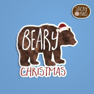 A pun sticker with the phrase 'beary Christmas' featuring a bear wearing a santa hat.  Sticker is on a blue background with a sticky puns logo in the top right corner.