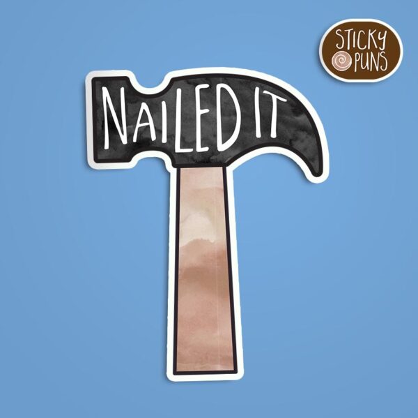 A pun sticker with the phrase 'Nailed It!' written on a hammer. Sticker is on a blue background with a sticky puns logo in the top right corner.