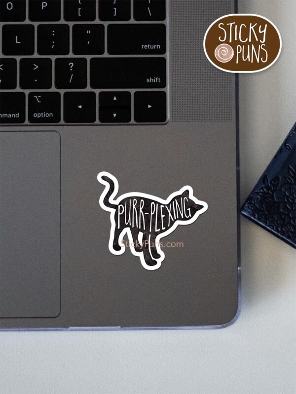 PURRplexing - cute cat pun sticker shown stuck on a laptop