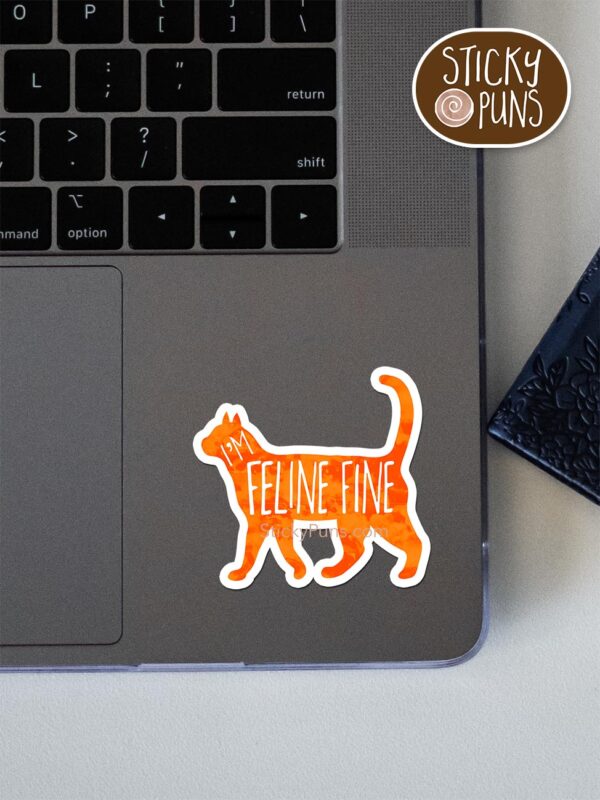 FELINE fine - cute cat pun sticker shown stuck on a laptop