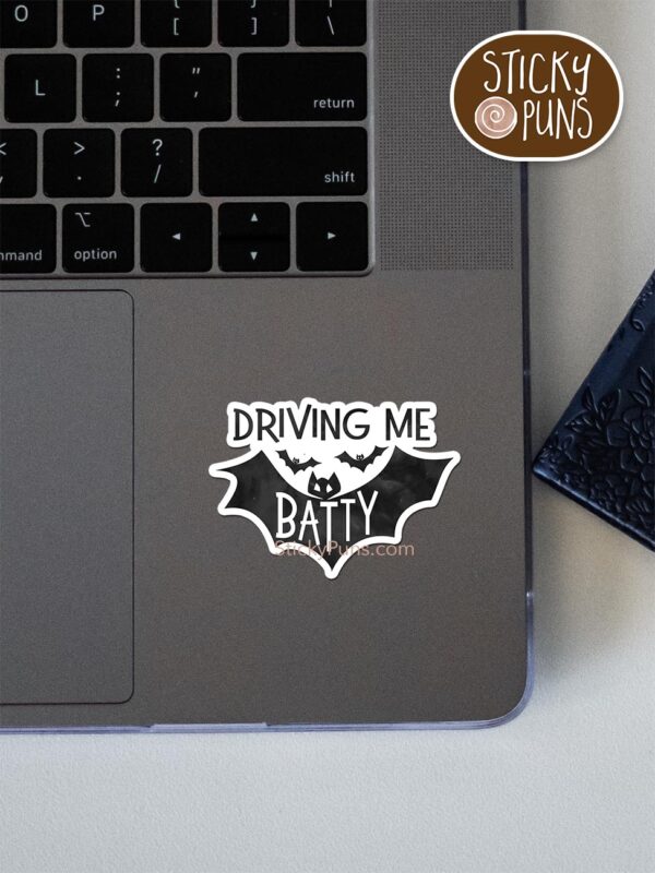 driving me batty pun sticker shown stuck on a laptop