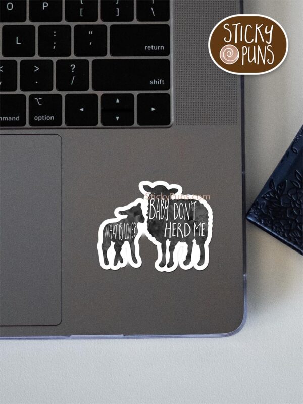 what is love? baby don't herd me pun sticker shown stuck on a laptop