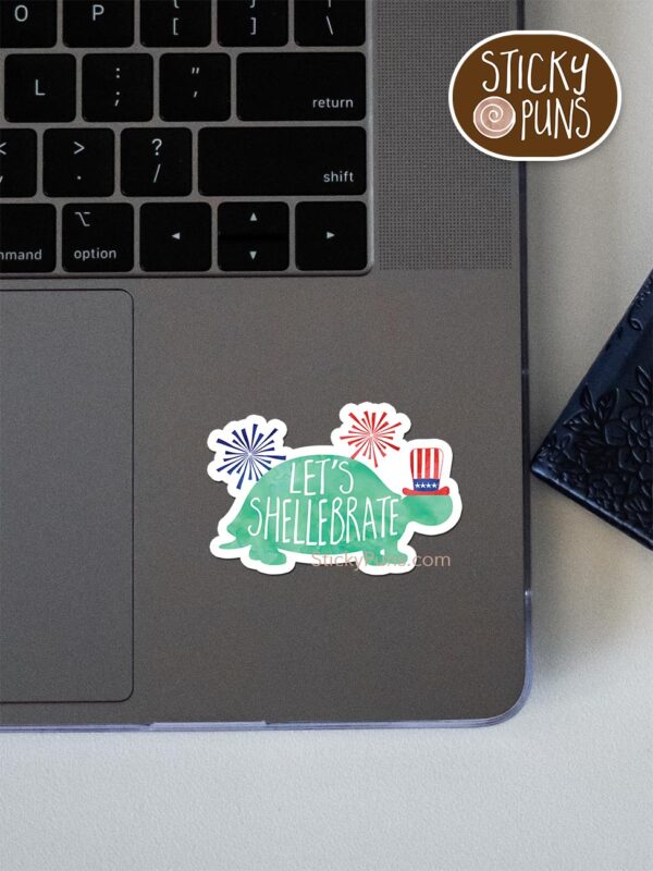 Let's Shellebrate! pun sticker shown stuck on a laptop