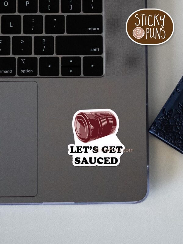 'Let's Get SAUCED' canned cranberry sauce pun sticker shown stuck on a laptop