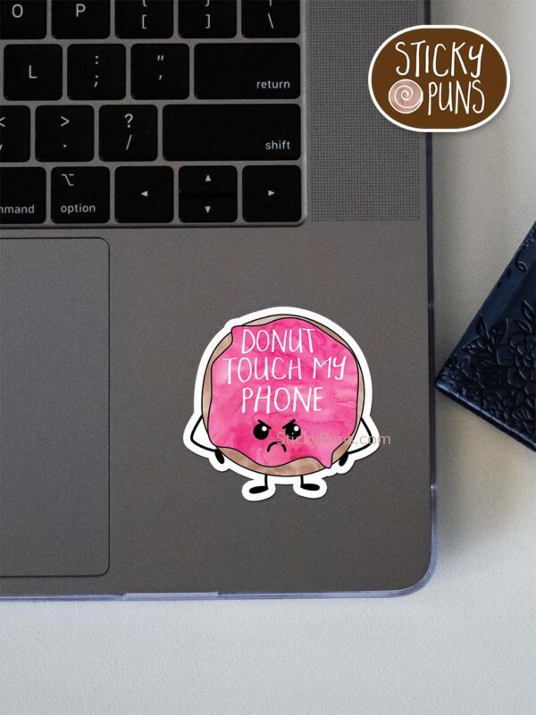 DONUT Touch My Phone pun sticker shown stuck on a laptop