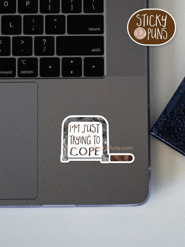 I'm Just Trying to COPE pun sticker shown stuck on a laptop