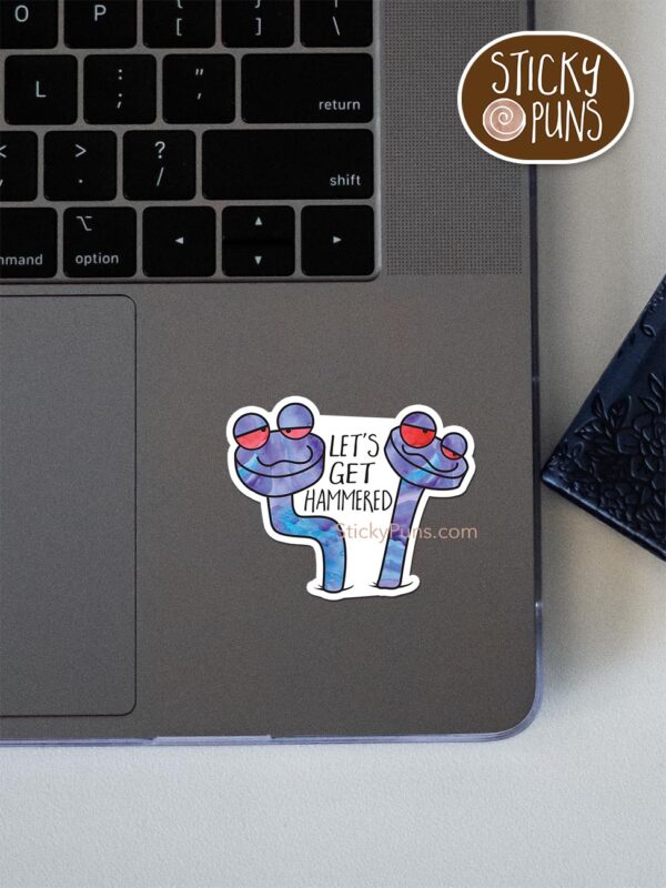 Let's get HAMMERED pun sticker shown stuck on a laptop