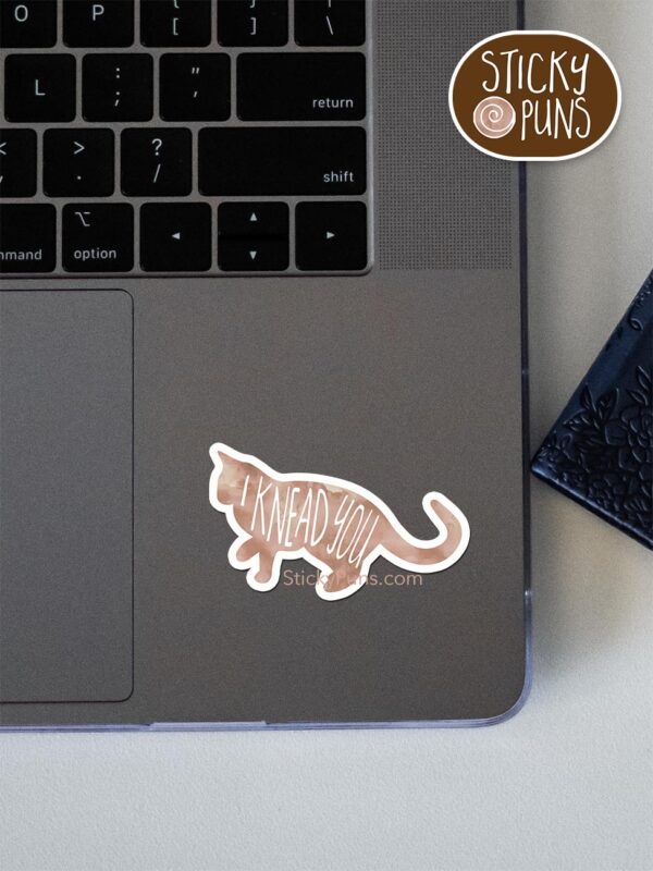 I knead you pun sticker shown stuck on a laptop