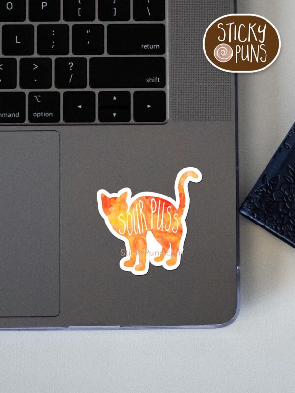 sourpuss pun sticker shown stuck on a laptop