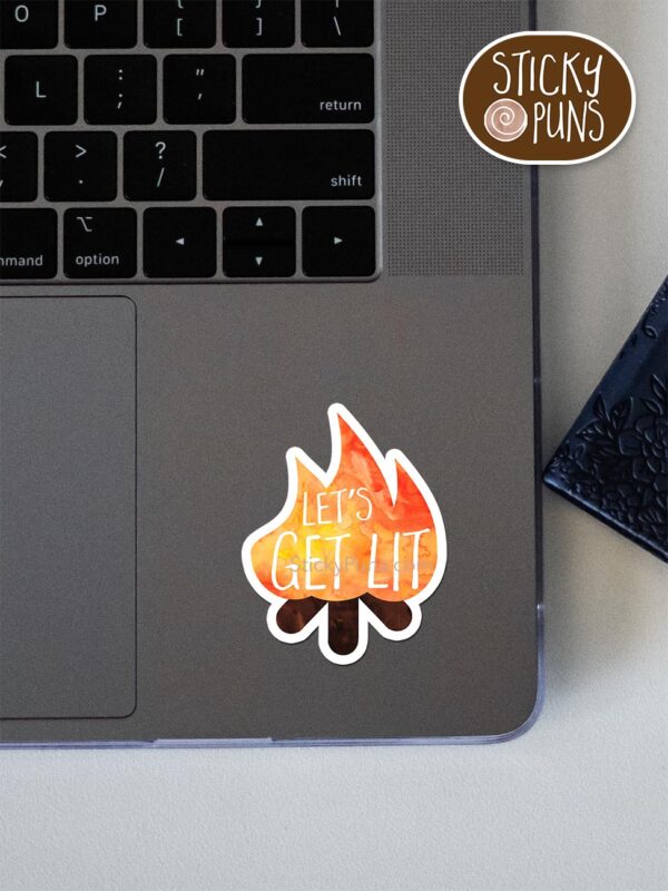 lets get lit pun sticker shown stuck on a laptop