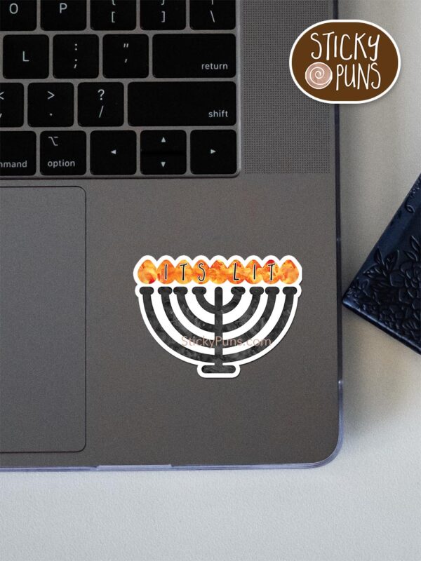 It's lit - Menorah pun sticker shown stuck on a laptop