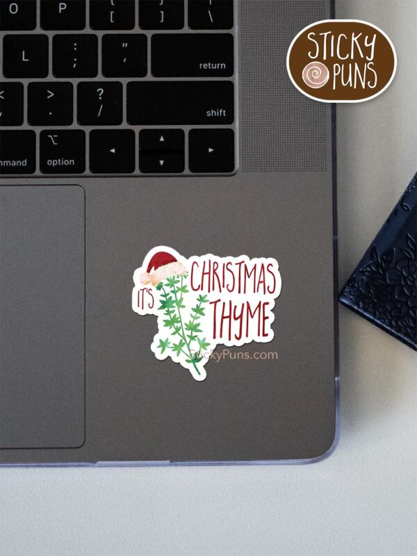 it's christmas thyme pun sticker shown stuck on a laptop