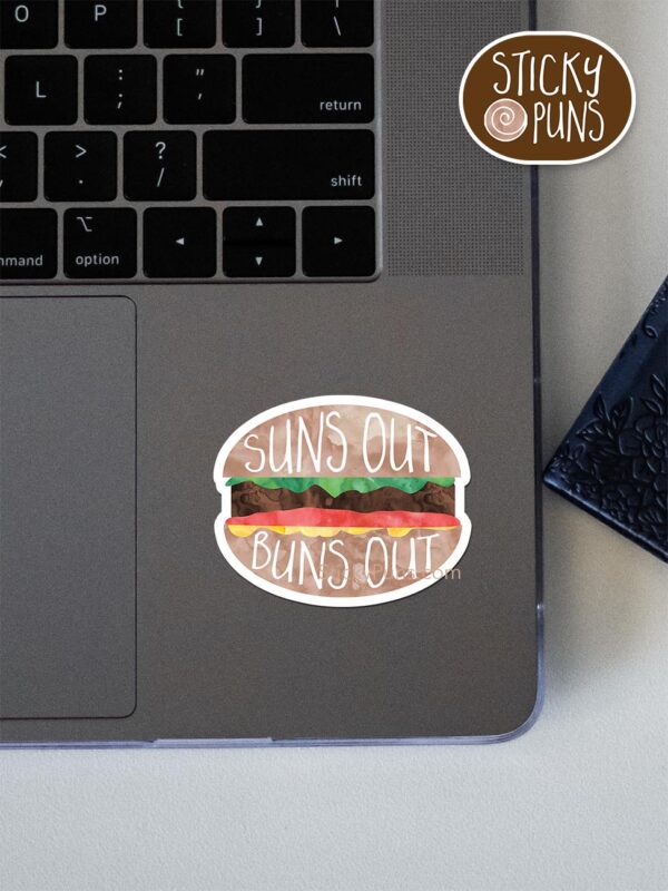 suns out buns out pun sticker shown stuck on a laptop