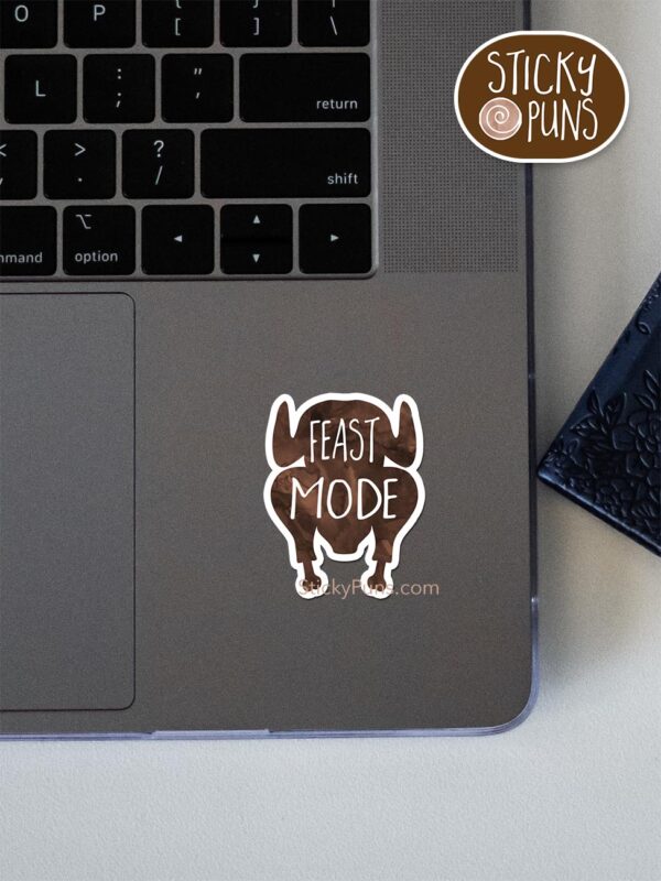 feast mode pun sticker shown stuck on a laptop